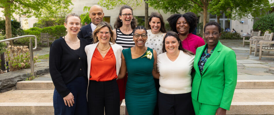 Group of people standing together, smiling.