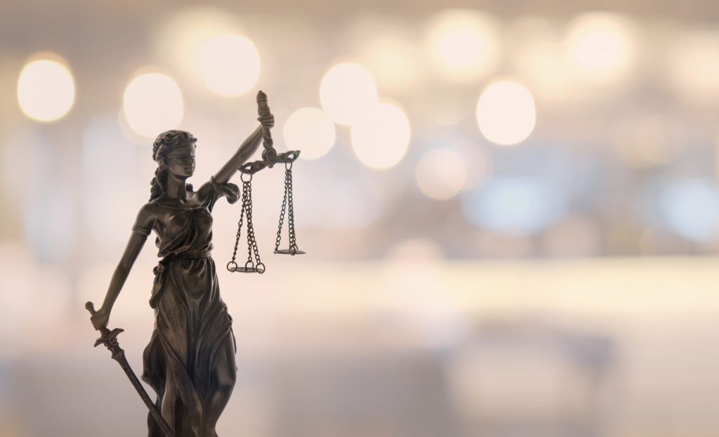 Lady Justice statue in focus against out of focus background