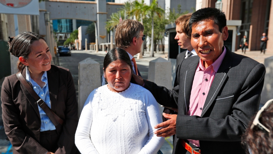 Eloy Rojas Mamani, right, gestures towards his wife Etelvina Ramos Mamani, while attorneys stand next to and behind them