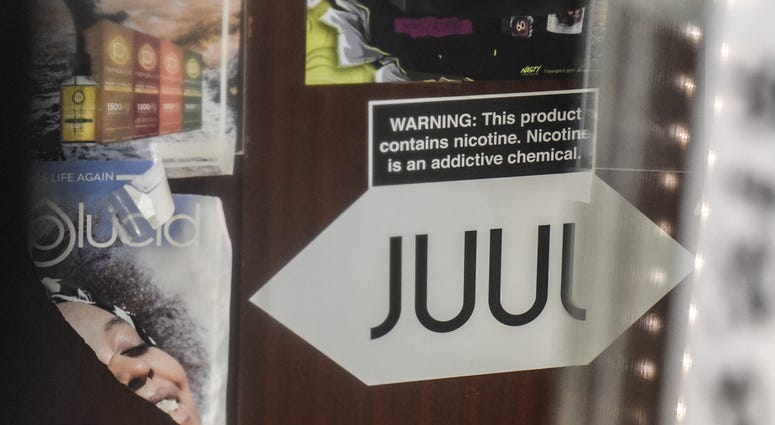 JUUL logo with a warning sign posted above it