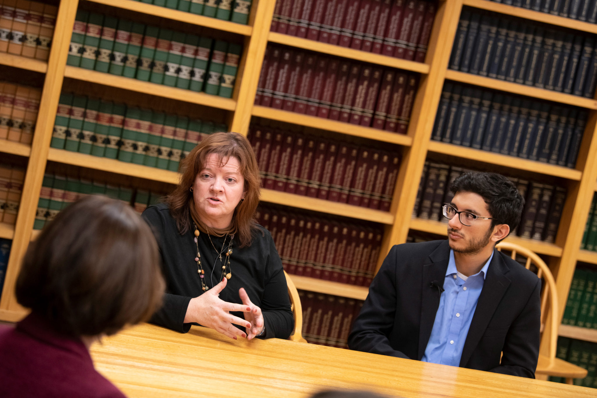 Julie McCormack (left) sits with student at the WilmerHale Legal Services Center