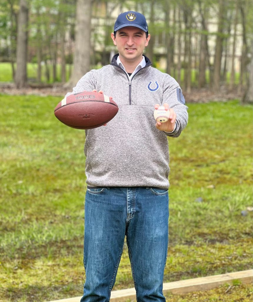 Eli Nachmany with a football and baseball